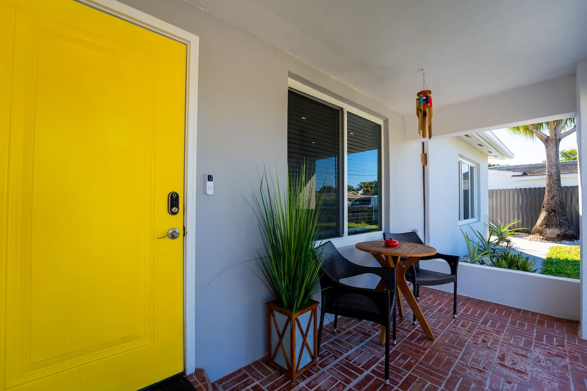 Yellow front door beside an outdoor seating area